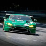 Voiture de course verte sur circuit en pleine dérive