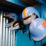 Casques de karting suspendus au mur d'un atelier aux murs bleus