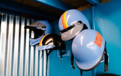 Casques de karting suspendus au mur d'un atelier aux murs bleus