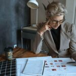 Une femme en costume examine des plans sur un bureau