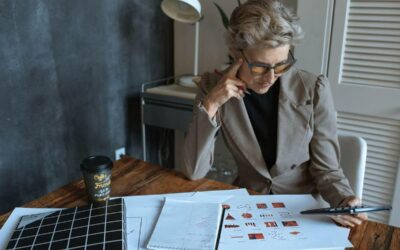 Une femme en costume examine des plans sur un bureau