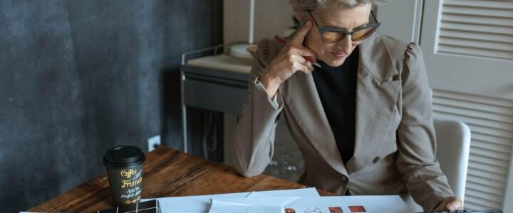 Une femme en costume examine des plans sur un bureau