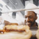 Chef souriant préparant des plats dans une cuisine moderne