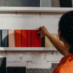 Personne sélectionnant des couleurs de peinture sur une étagère blanche