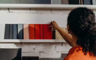 Personne sélectionnant des couleurs de peinture sur une étagère blanche