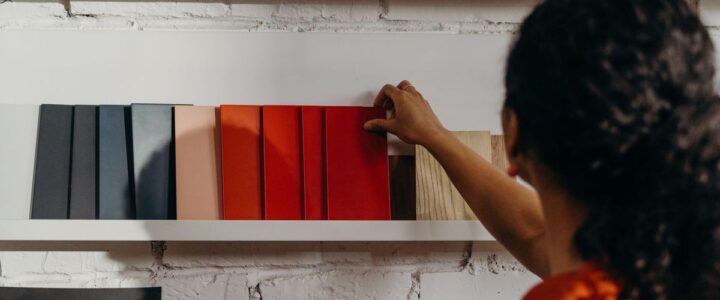 Personne sélectionnant des couleurs de peinture sur une étagère blanche