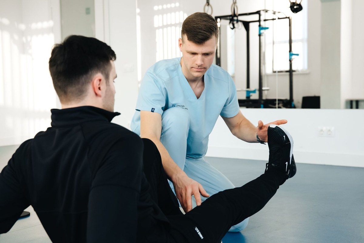Professionnel médical assiste un client dans un exercice de flexibilité