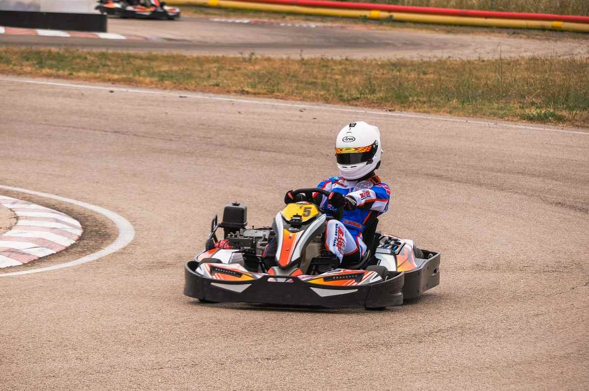Un pilote de karting tourne sur une piste de terre avec son kart Un pilote de karting tourne sur une piste de terre avec son kart