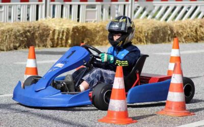 Enfant pilotant un kart bleu sur une piste de course miniature