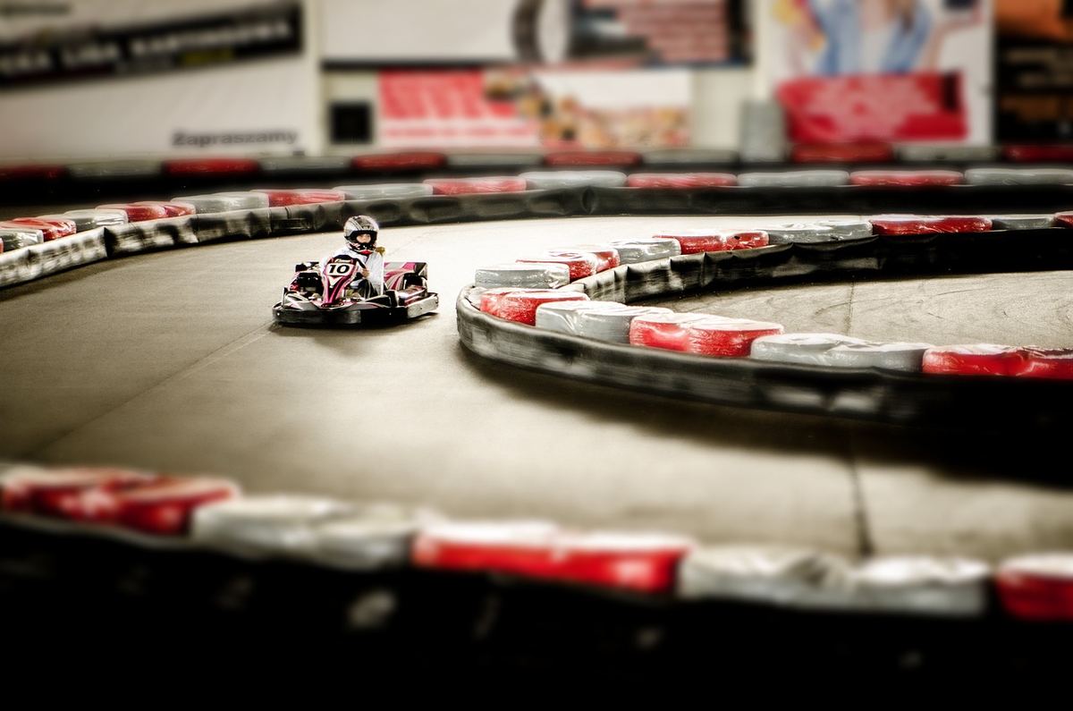 Un kart dérive sur un virage de circuit indoor