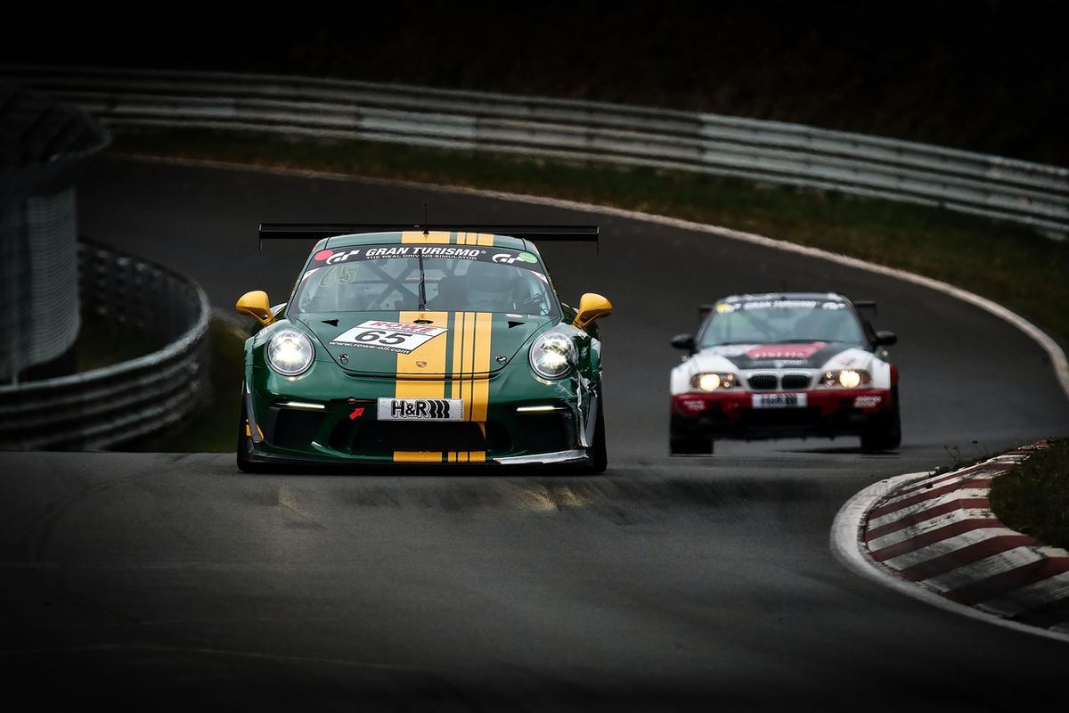 Deux voitures de course, une verte et une blanche, naviguent en virage sur circuit