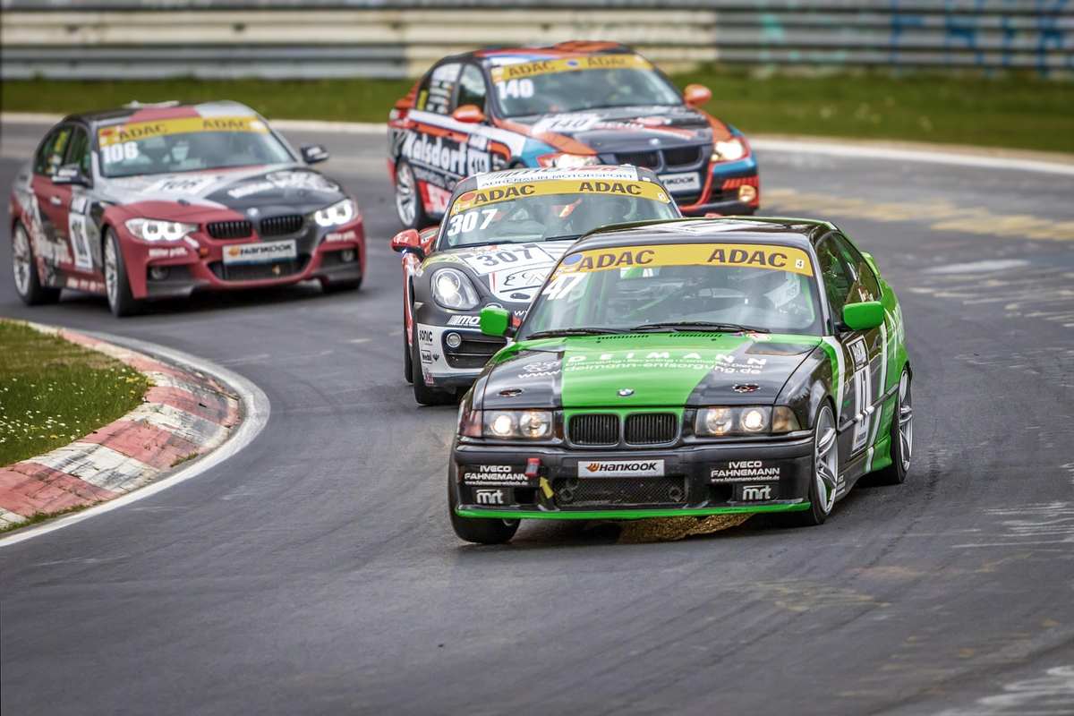 Plusieurs voitures de sport racing naviguent un virage du circuit Plusieurs voitures de sport racing naviguent un virage du circuit