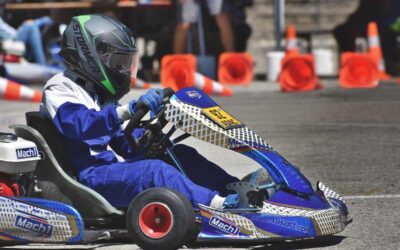 Conducteur dans kart bleu Mach1 sur circuit, casque noir, cônes orange