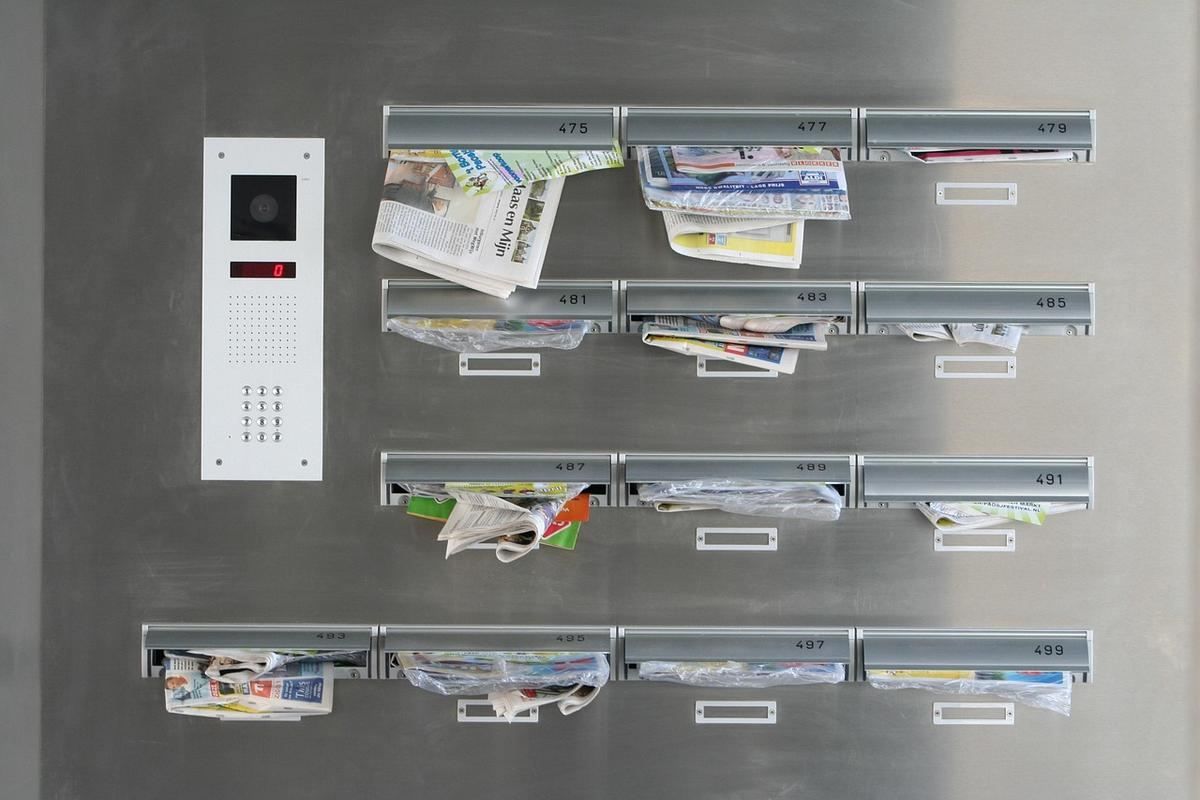 Boîtes aux lettres remplies de courrier sur une porte d'entrée Boîtes aux lettres remplies de courrier sur une porte d'entrée