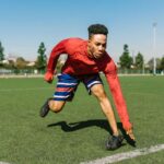 Homme en mouvement sur un terrain de sport, ligne blanche, arbres et ciel