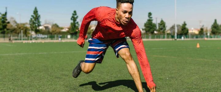 Homme en mouvement sur un terrain de sport, ligne blanche, arbres et ciel