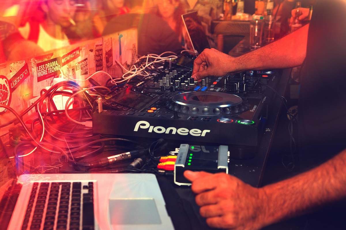Un DJ utilise une platine Pioneer et un ordinateur portable