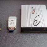 Carte SD, clé USB, et boîtier externe sur fond gris