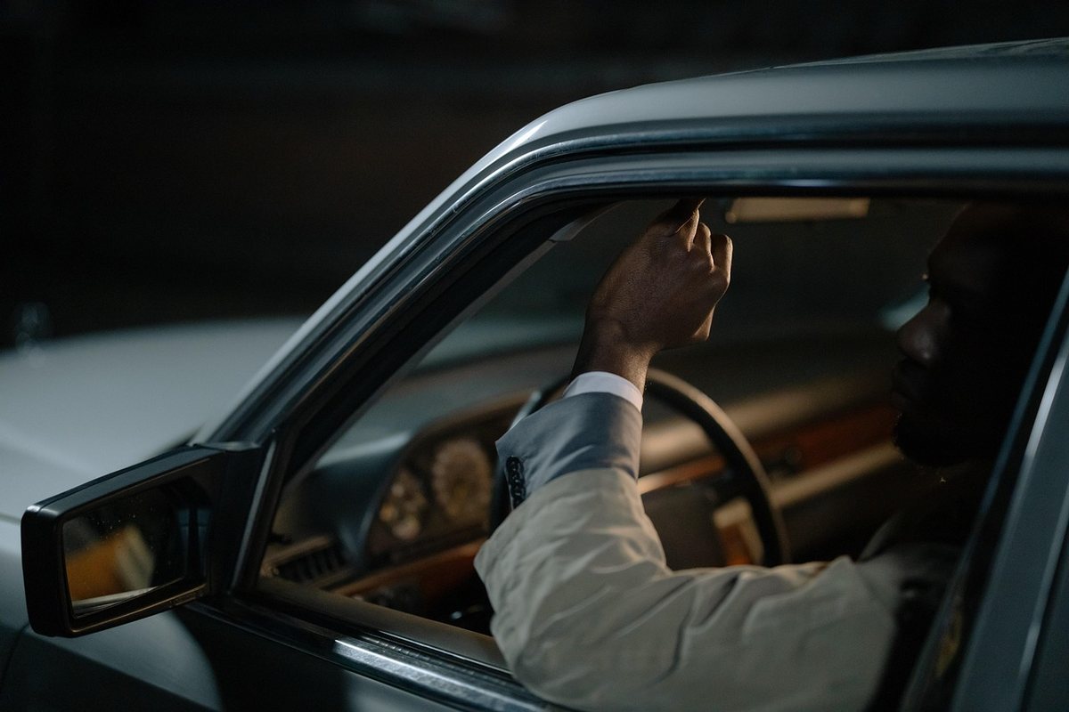 Un homme dans une voiture atteint vers le tableau de bord Un homme dans une voiture atteint vers le tableau de bord